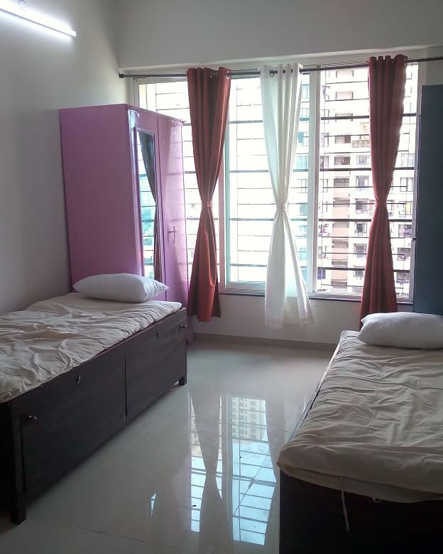 A girls-only sharing room with two beds and floor-to-ceiling windows